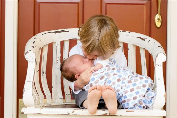 Ребенок целует младенца