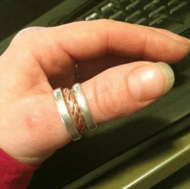Женщина носит кольцо: на большом пальце: на среднем пальце: плетеное и из двух металлов