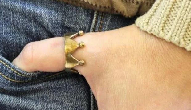 Как женщины носят кольца: золотая корона на большом пальце руки