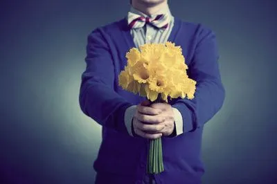 Мужчина дарит желтые цветы