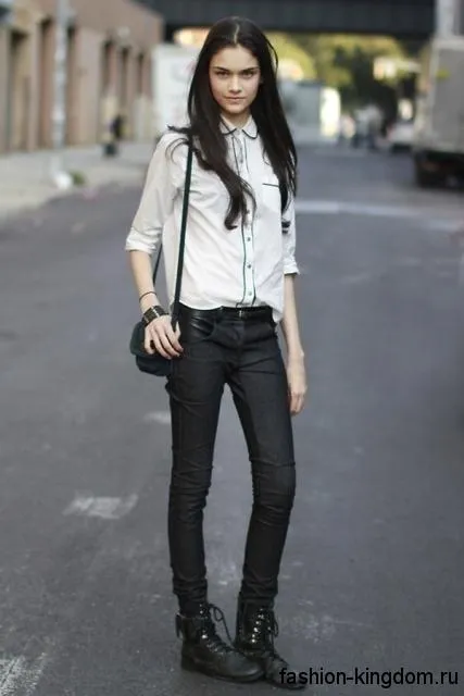 Черные джинсы на каждый день сочетаются с рубашкой белого цвета с черной отделкой, массивными ботинками на низком ходу и не большой черной сумочкой.